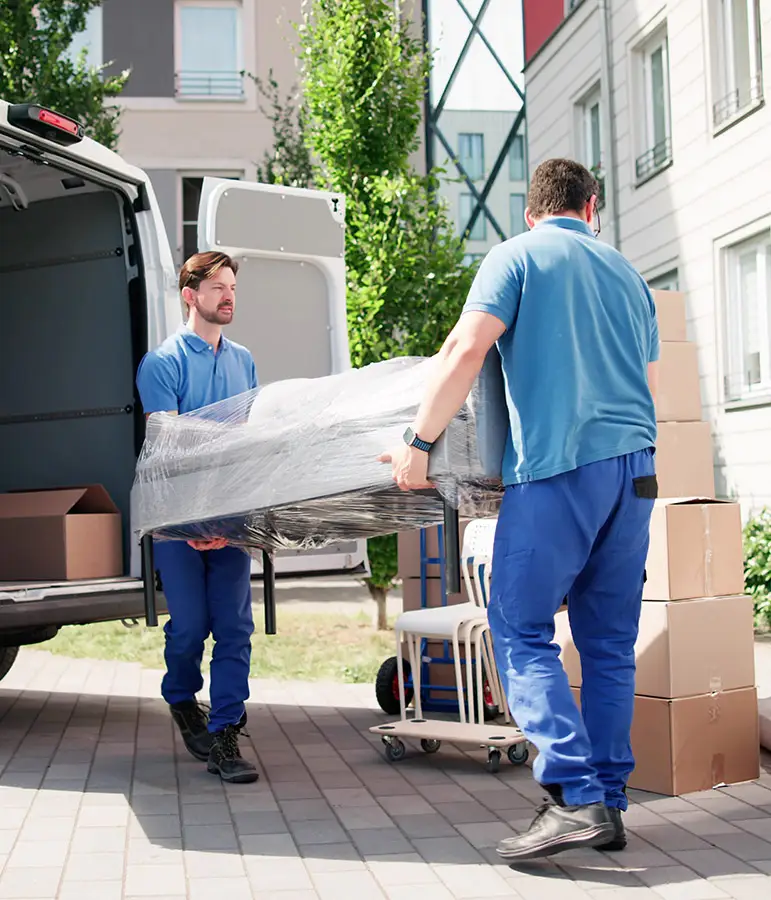 Kehrmann Service Zwei Umzugshelfer bringen ein Möbelstück in einen Umzugswagen