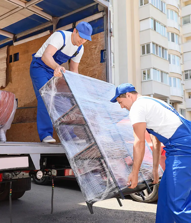 Kehrmann Service Zwei Umzugshelfer bringen ein Regal in einen Umzugswagen